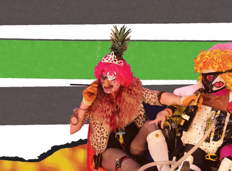  Two people in colourful fancy dress and ridiculous headwear with a bottle of champagne. They seem to be bursting with energy, leaping up in front of the two green strips from the cover of UK accessibility Part M documents.