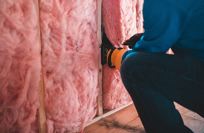 A worker installs insulation in a house main imagejpg