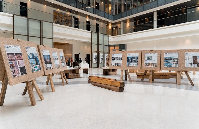 Selection of art on easels in large open space with concrete floor.