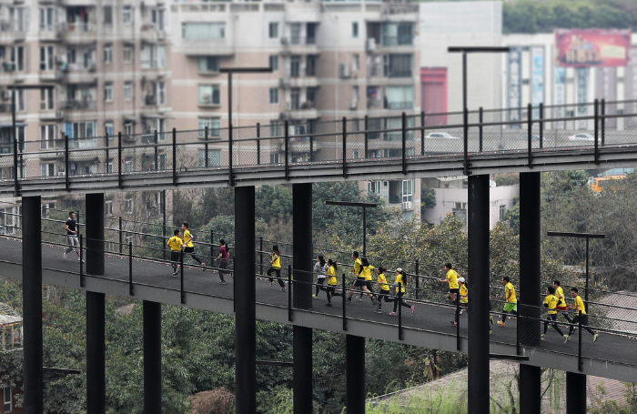 Runners in yellow on a track in West Village China 700x455png