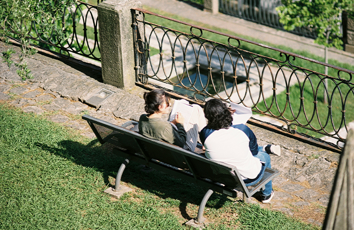 Two people working and sitting on a park benchjpg