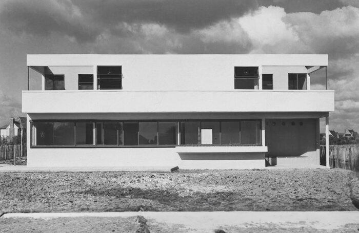 Black and white photograph of the façade of a white Modernist house.