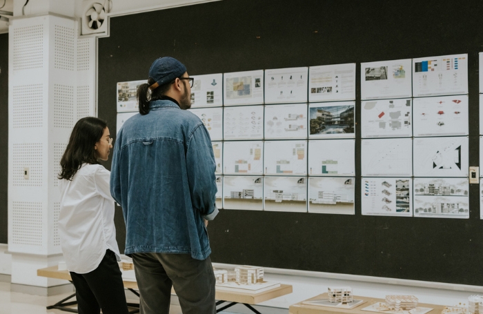 Two people chat while looking at an architects exhibitionjpg