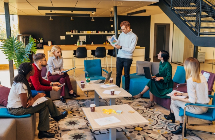 A group of people in a modern office sitting in a circle having a meetingjpg