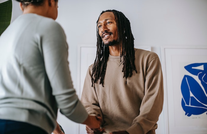 Two people shaking hands and smilingjpg
