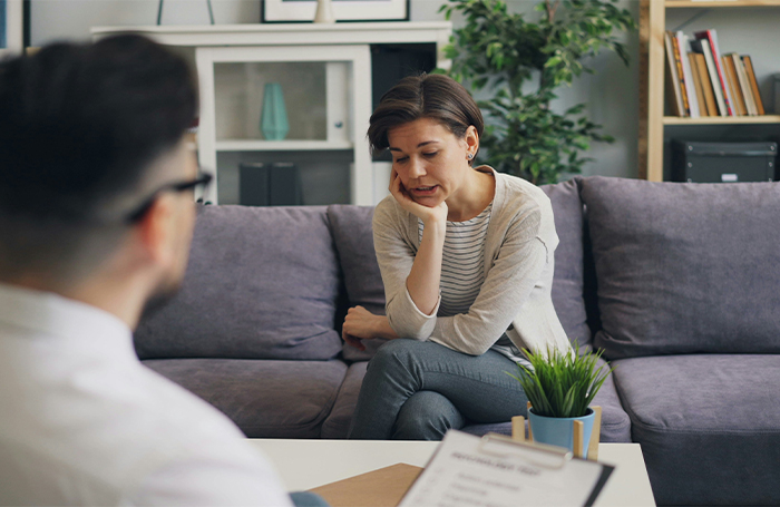 Woman sitting on sofa in a therapy sessionjpg