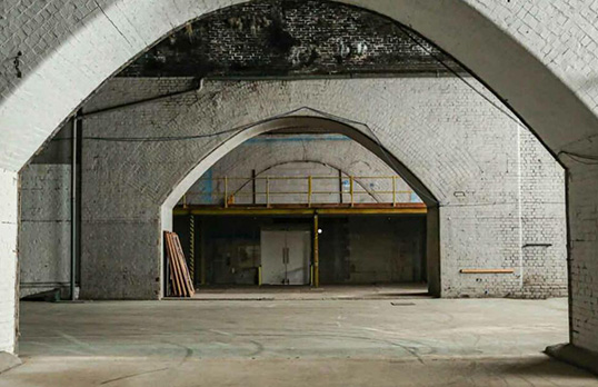 Brick vault space with bare concrete floor