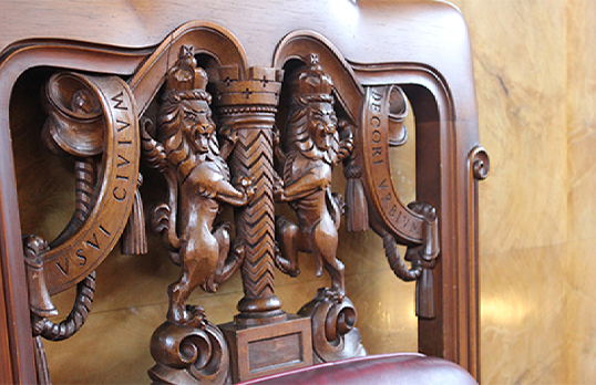 Wood carving of the RIBA lion logo on a chair