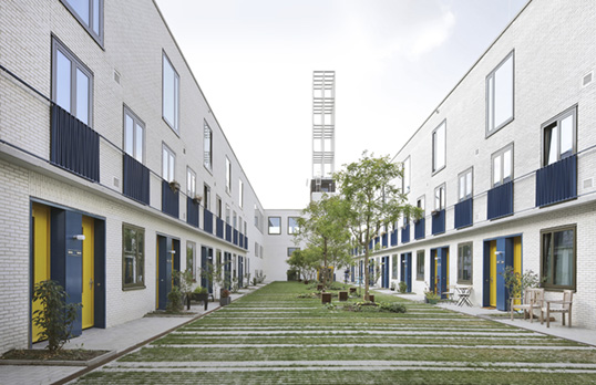 Courtyard lined on either side by housing entrances