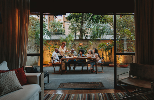 View through large door of family sitting around an outdoor table