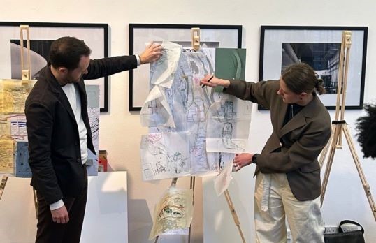 Two architecture students presenting sketches set on an easel