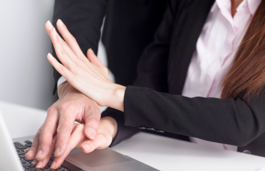 Woman fending off an unwanted male hand at work