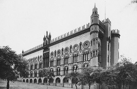 Black and white photo of a ornate gothic revival carpet factory with round towers on each corner and detailed windows on the side
