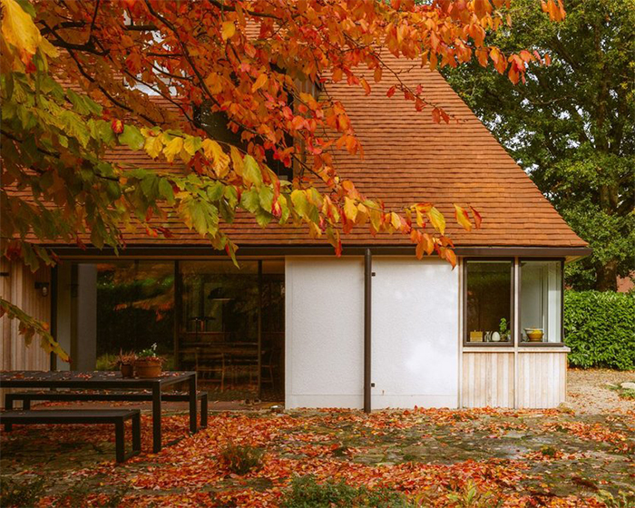 Middle Avenue home with steep gable rood surrounded by trees with leaves changing colour