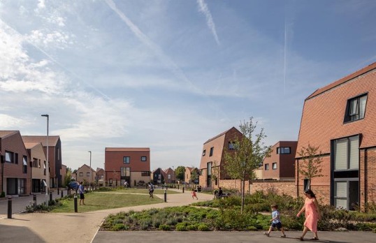 Terracotta tile clad abnormally shaped dwellings with large open greenspace public realm 