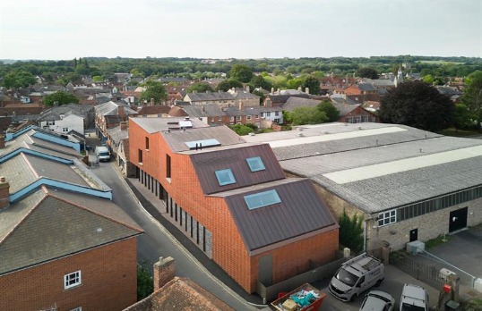 Mutli-apexed large brick building set among industrial buildings