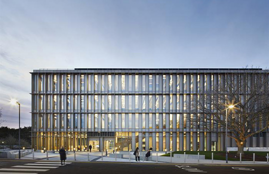 Large modern glass fronted square office block building