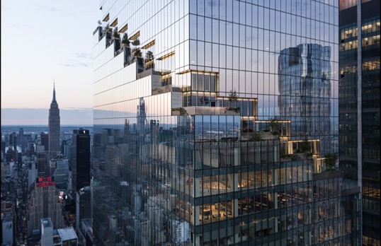 Photograph of glass skyscraper reflecting New York skyline with a series of windows cut back to form a pattern in the grid format.