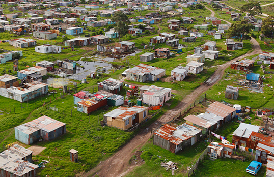 Aerial view of a cluster of homes surrounded by grass in a township in South Africa 