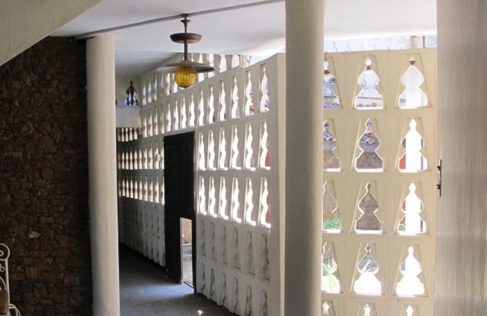 White cut out walls and columns leading to a courtyard in Nadesan House, Sri Lanka