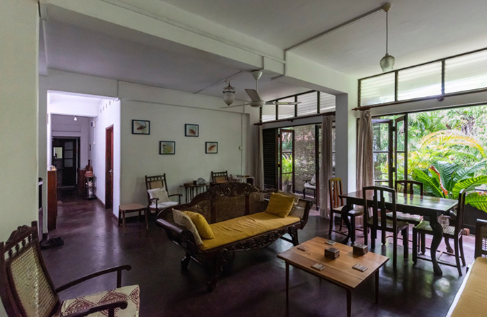 Open concept living room with large windows and dark wooden furniture in Senanayake apartments - Colombo, Sri Lanka