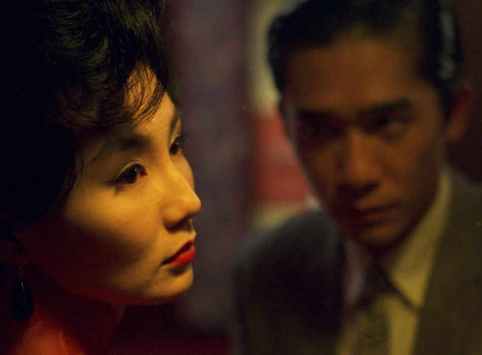 Close up of a man in a suit looking at a woman with red lipstick, from the film In the Mood for Love