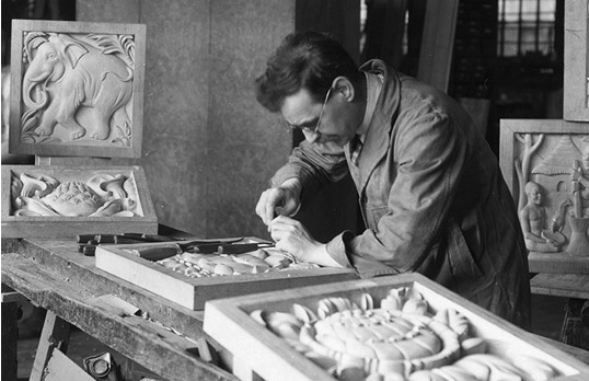 Denis Dunlop working in his studio on the panels of a screen