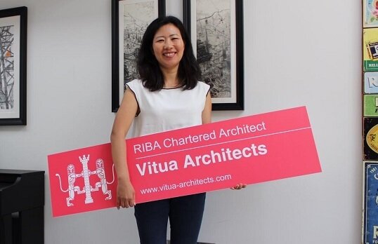Woman holding RIBA Site Signboards plaque