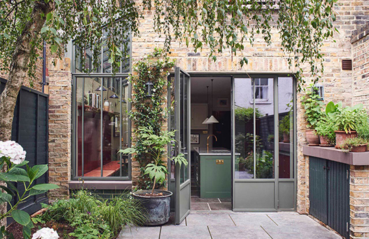  A botanic gardens-inspired glazed side return extension in verdant green steel