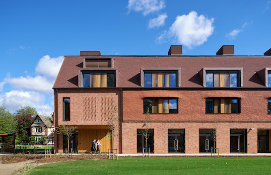 Brick Passivhaus house with grass in the foreground and blue sky