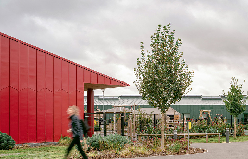 Alfreton Park SEND School red exterior with greenery and a person walking by