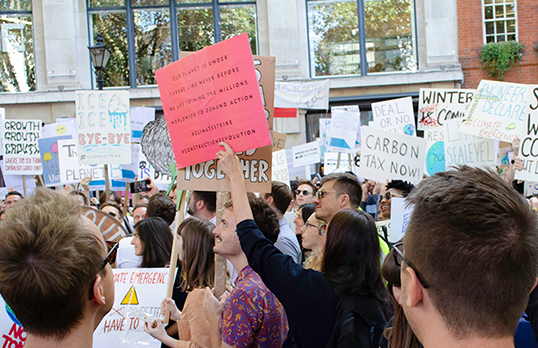Architects holding placards with a range of climate action themed messages