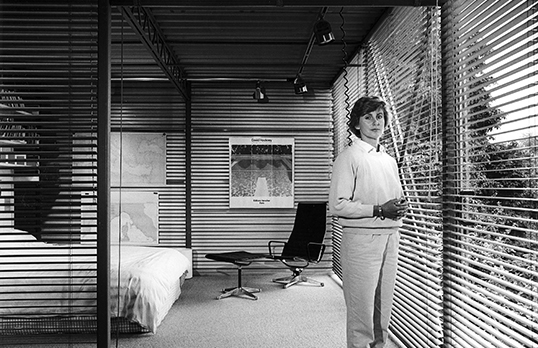 Radical Rooms - black and white photo of a woman in a room with walls with wooden slats