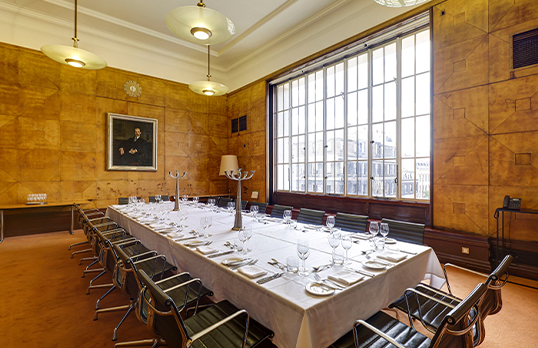 Long rectangular party table setup in the Aston Webb Room with large Art Deco window