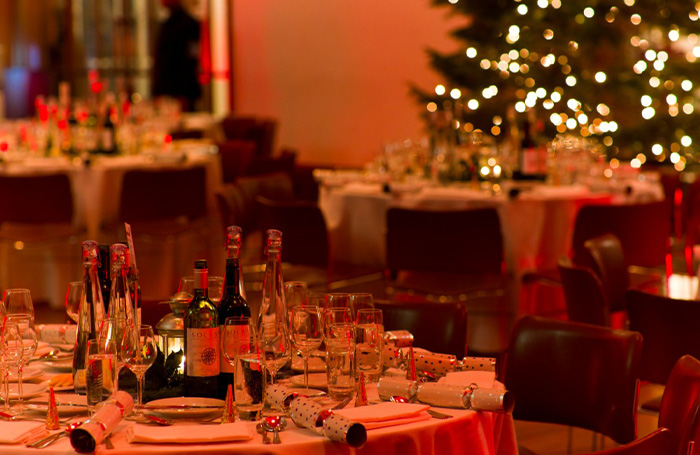 Festive table decorations on round tables with a Christmas tree in the background, Florence Hall - 66 Portland Place