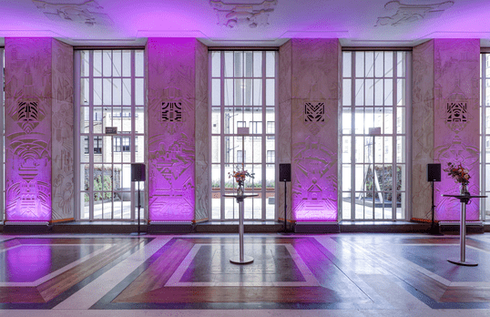 Florence hall floor-to-ceiling Art Deco windows with wall carvings and purple backlighting 