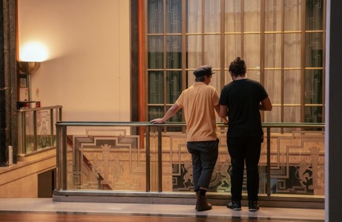 Two people discuss a film shoot in 66 Portland Place