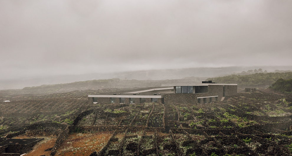 Adega Pico Winery and Hotel exterior surrounded by vineywards and clouds
