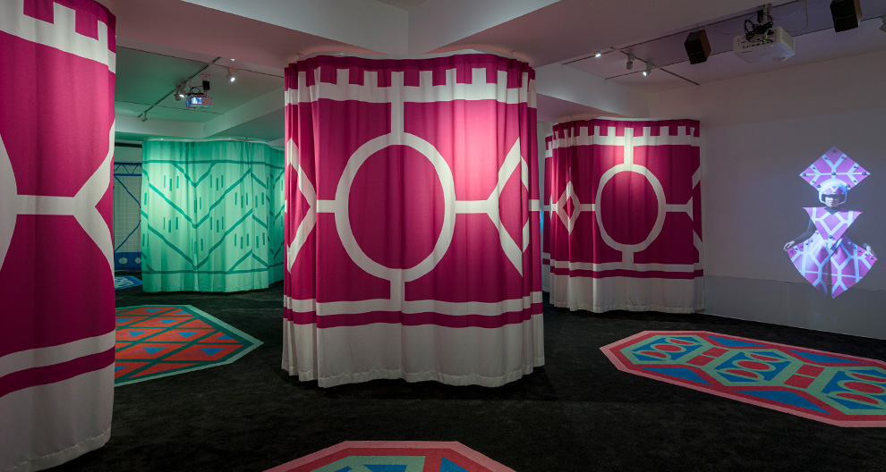Inside Radical Rooms gallery with pink and green patterned curtains hanging from the ceiling 
