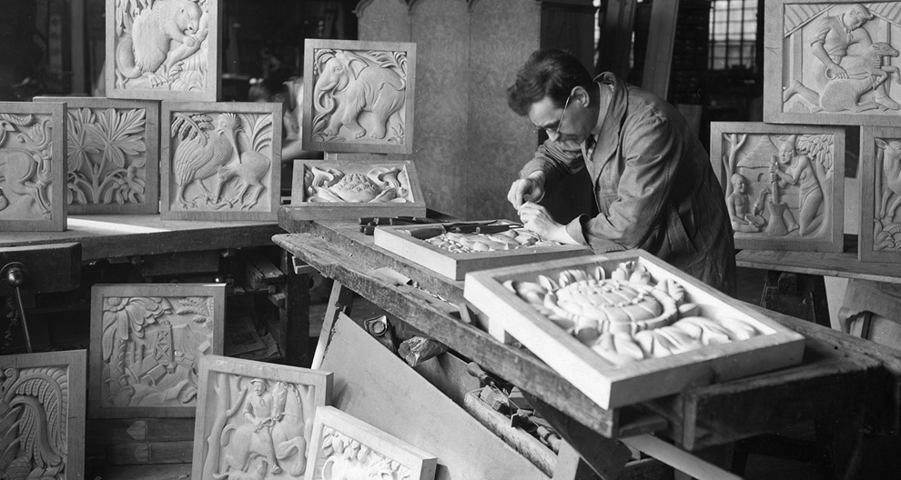 Denis Dunlop working in his studio on the panels of a screen