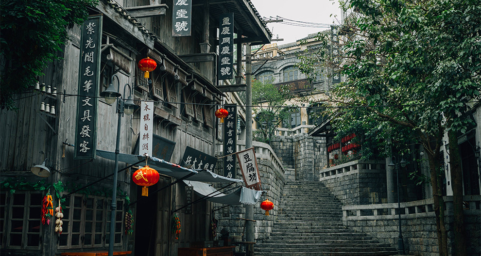 Photograph of a building and stairs with Chinese banners, flags and red lanterns