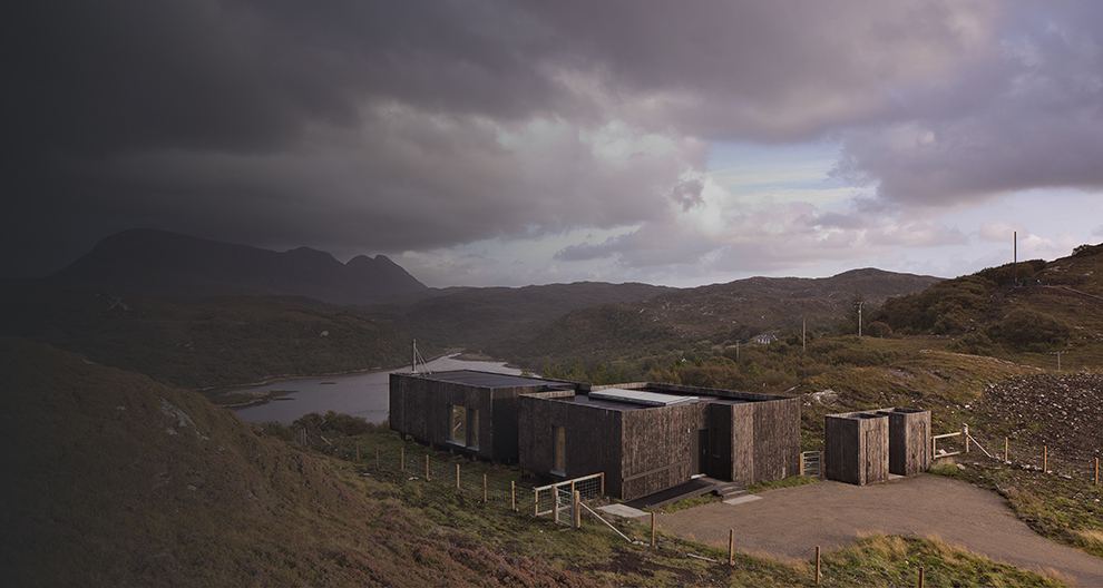 A modern low profile brown building between hills